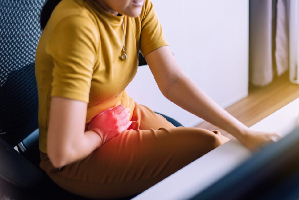 Woman having painful stomach ache during working at home